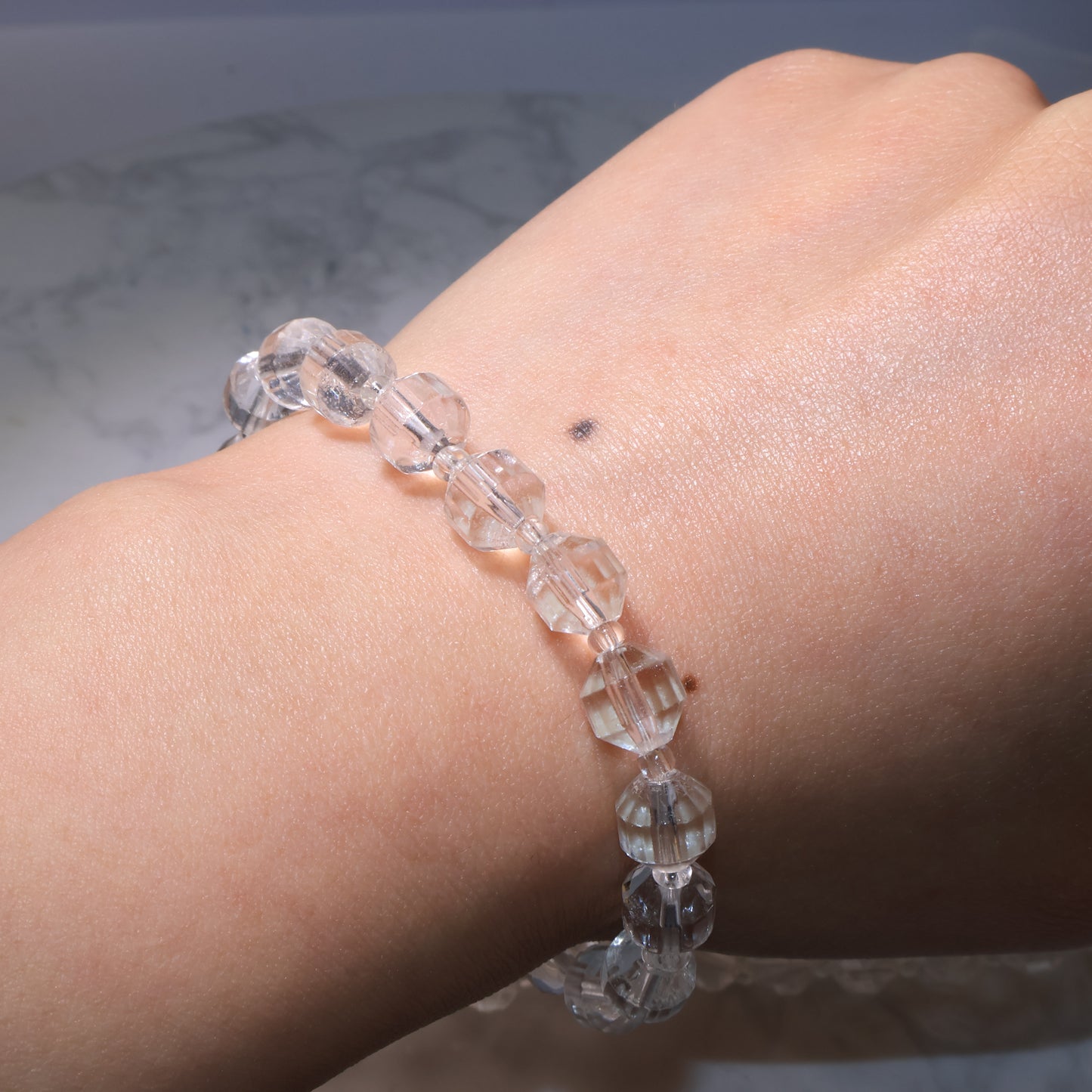 Bracelet worn on the wrist under natural light, showing subtle inclusions.