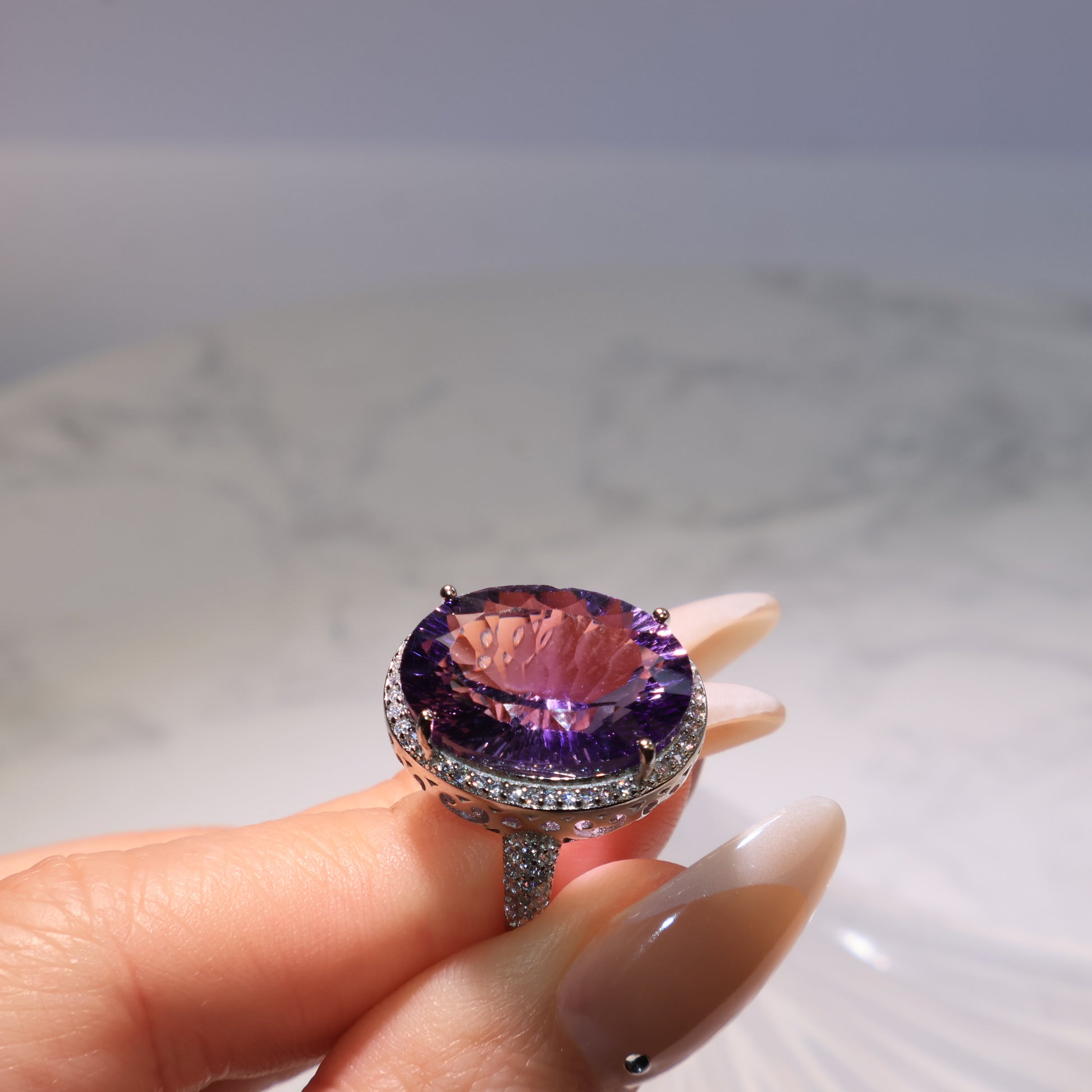 Close-up of the Amethyst ring held in hand, showing brilliance and faceted detailing.