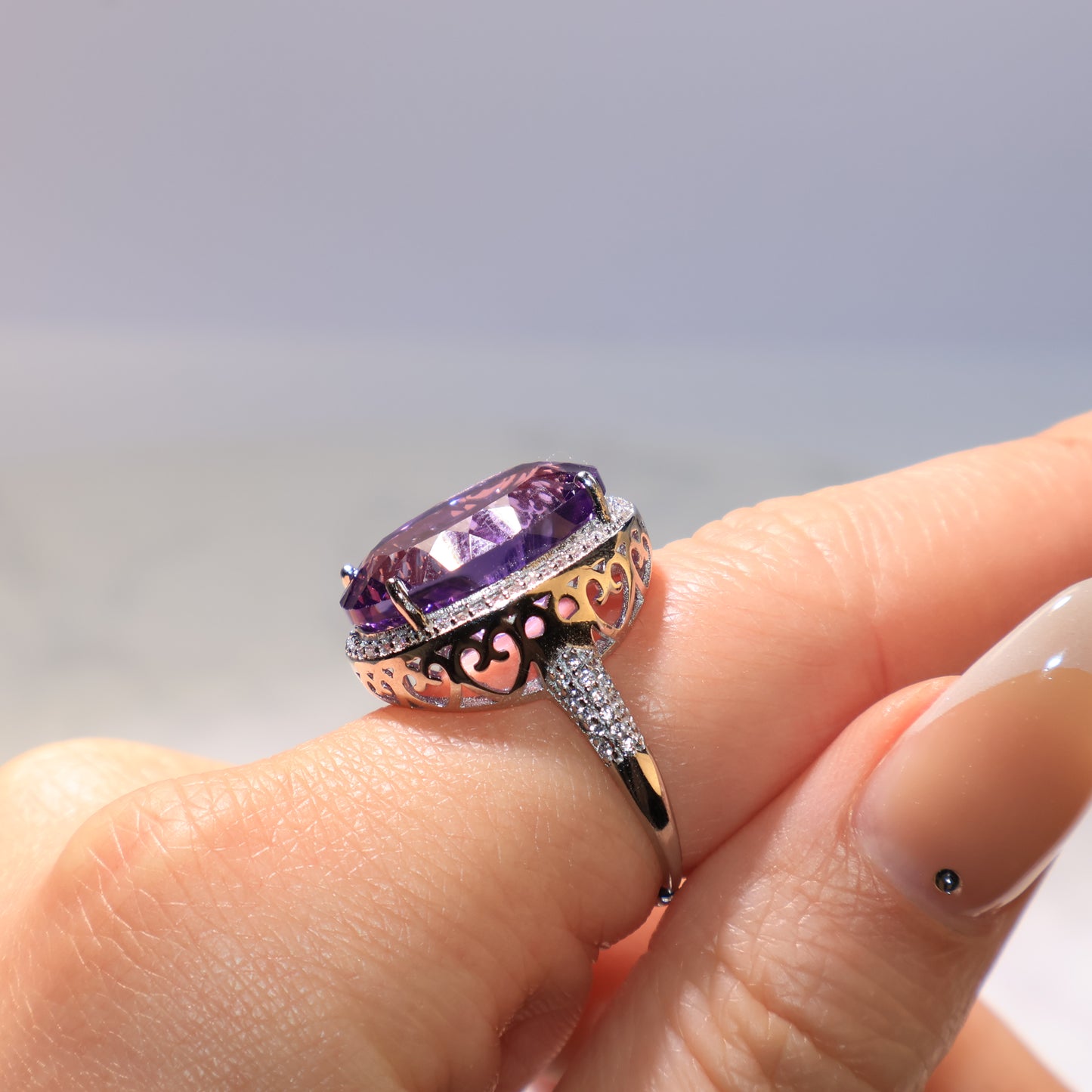 Side view of the Amethyst ring highlighting the silver band with delicate carved details.