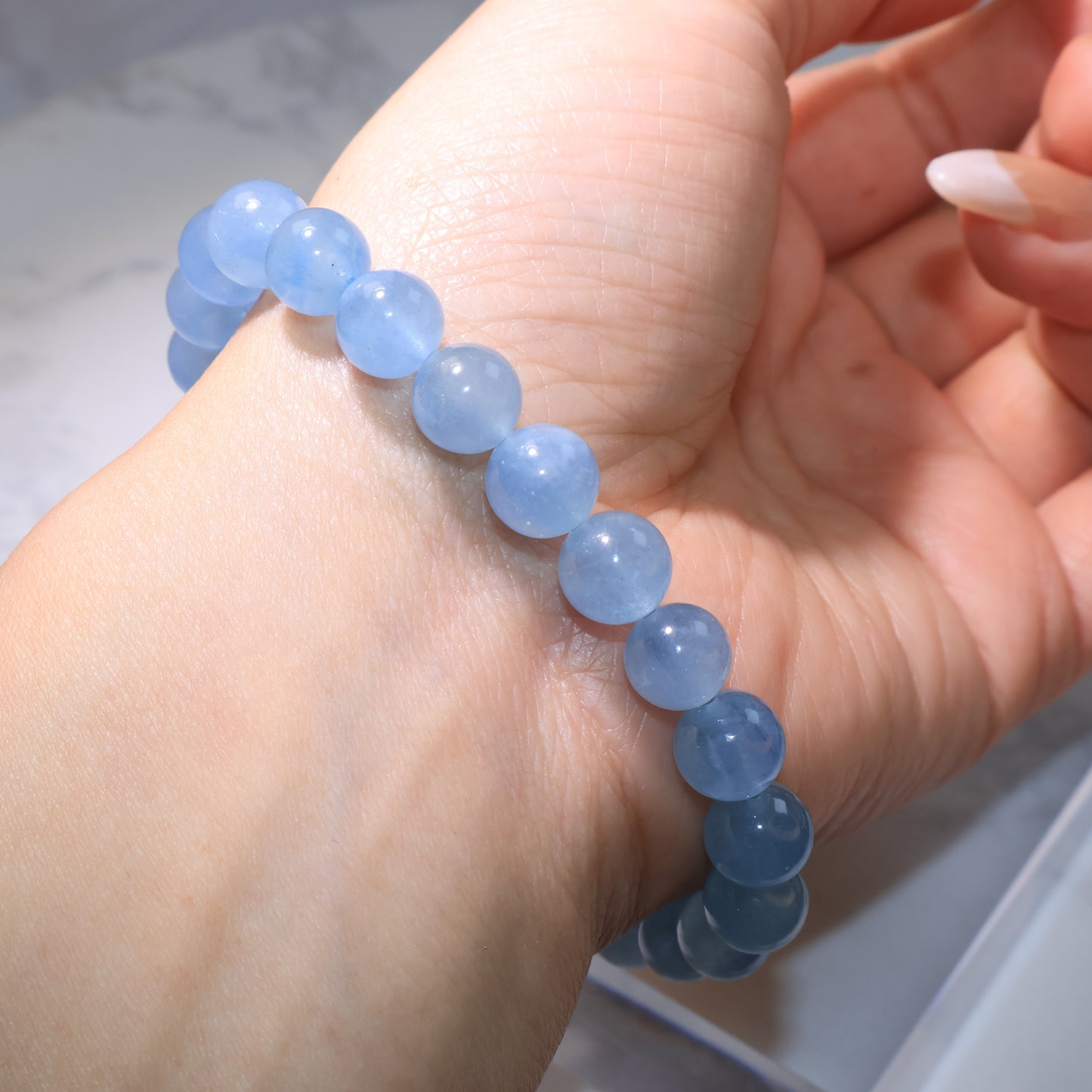 Side angle of aquamarine bracelet on wrist, showing elegant fit and gentle blue shine