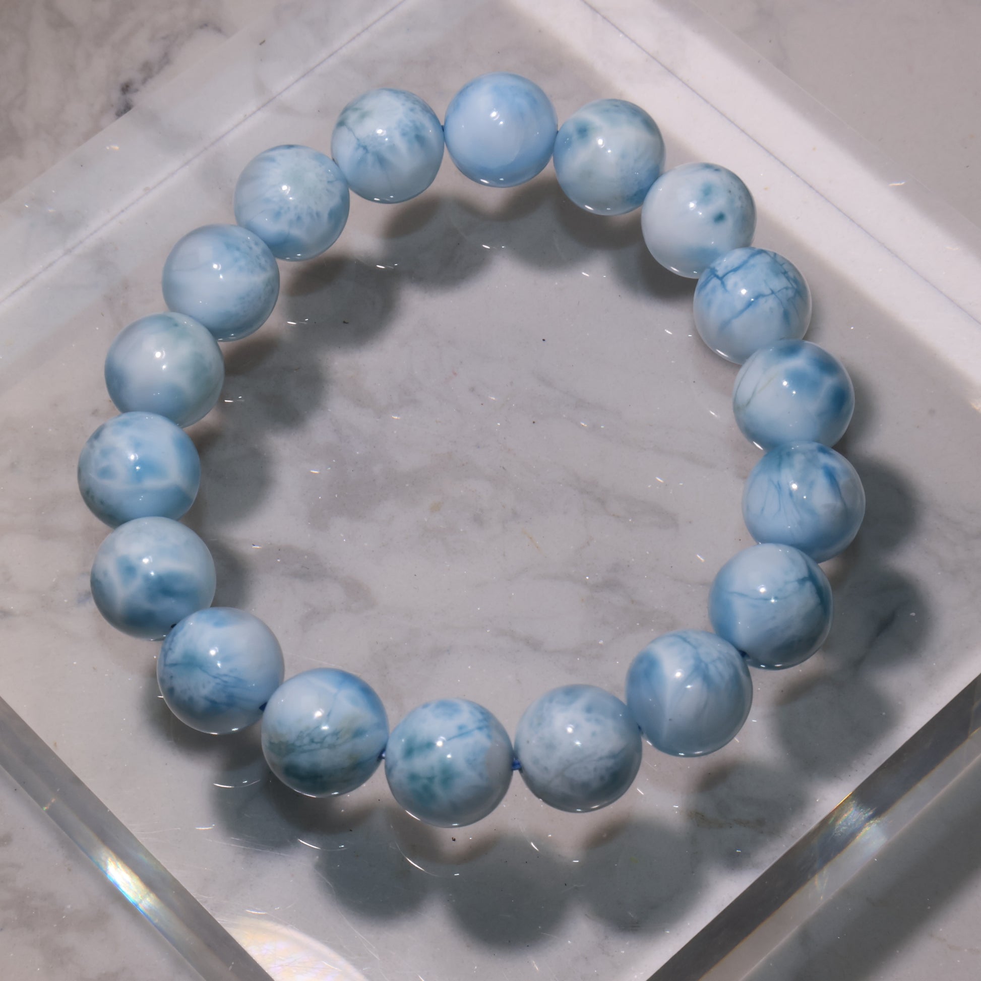 Macro shot of Larimar beads showing natural blue veins and white swirls