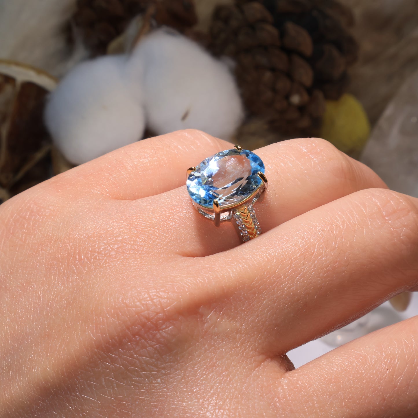 The Blue Topaz ring worn on hand, showing its elegant sparkle and refined dual-tone silver design under natural sunlight.