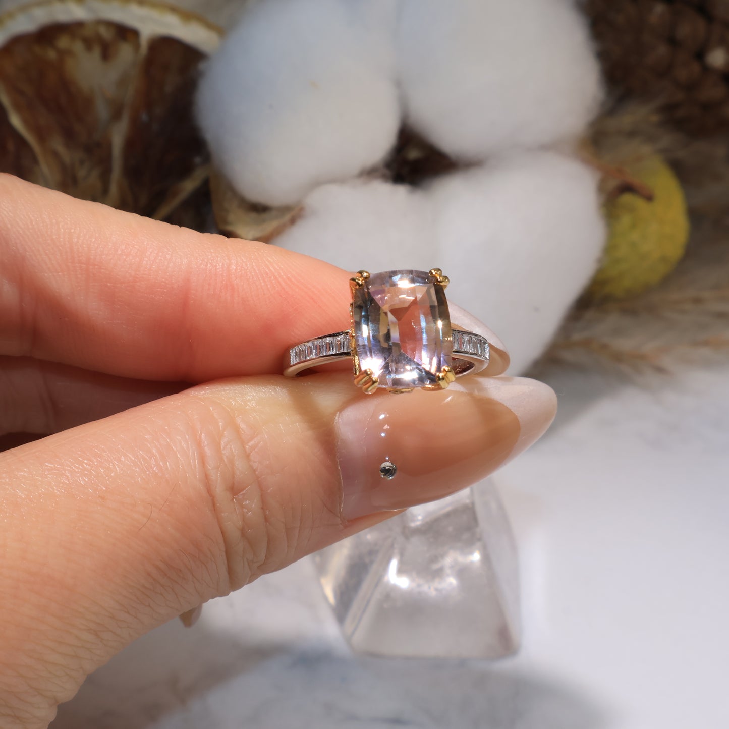 Hand holding the ametrine ring, showing its brilliance and clarity under natural light.