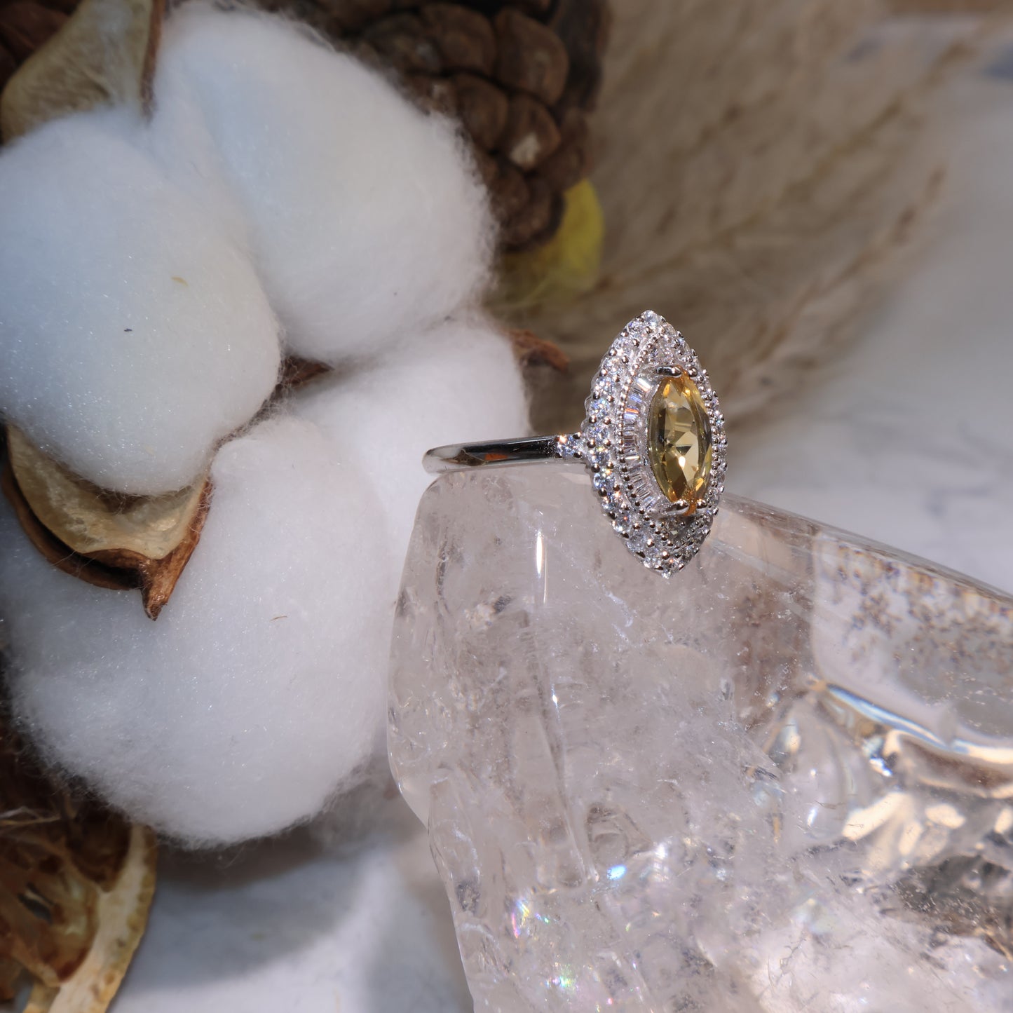 Side view of the citrine halo ring showing the detailed zircon setting around the gemstone.