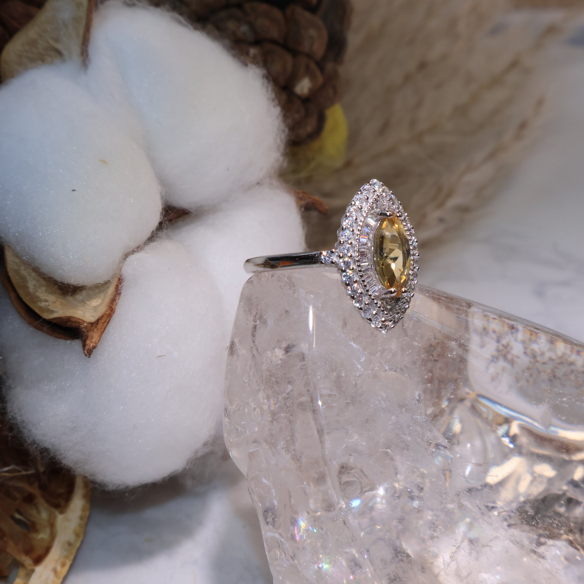 Side view of the citrine halo ring showing the detailed zircon setting around the gemstone.