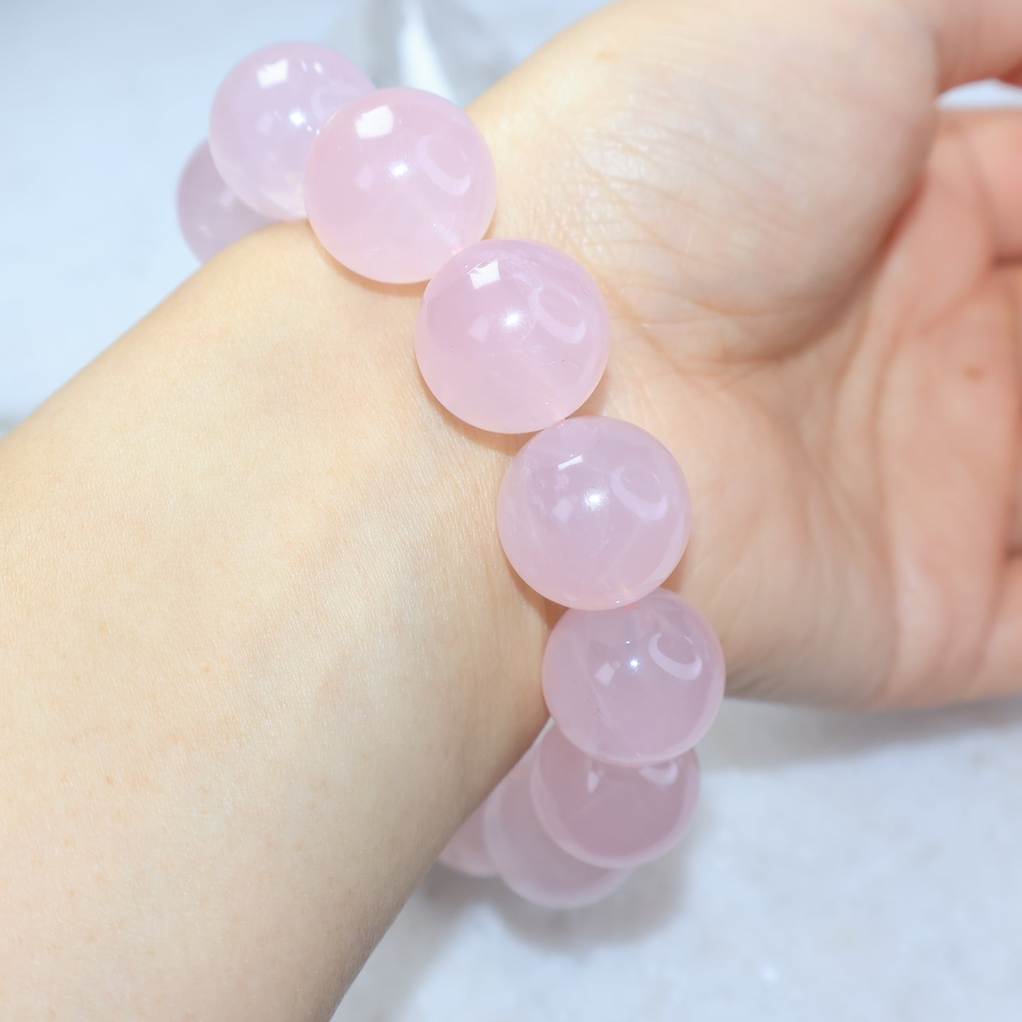 Close-up wrist shot of translucent pink rose quartz crystal bracelet