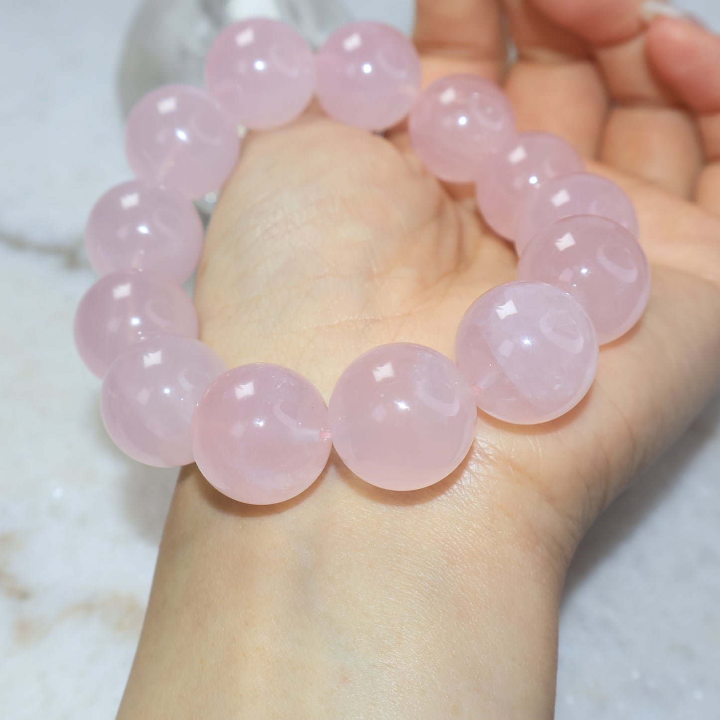 Natural rose quartz bracelet photographed on wrist under bright lighting