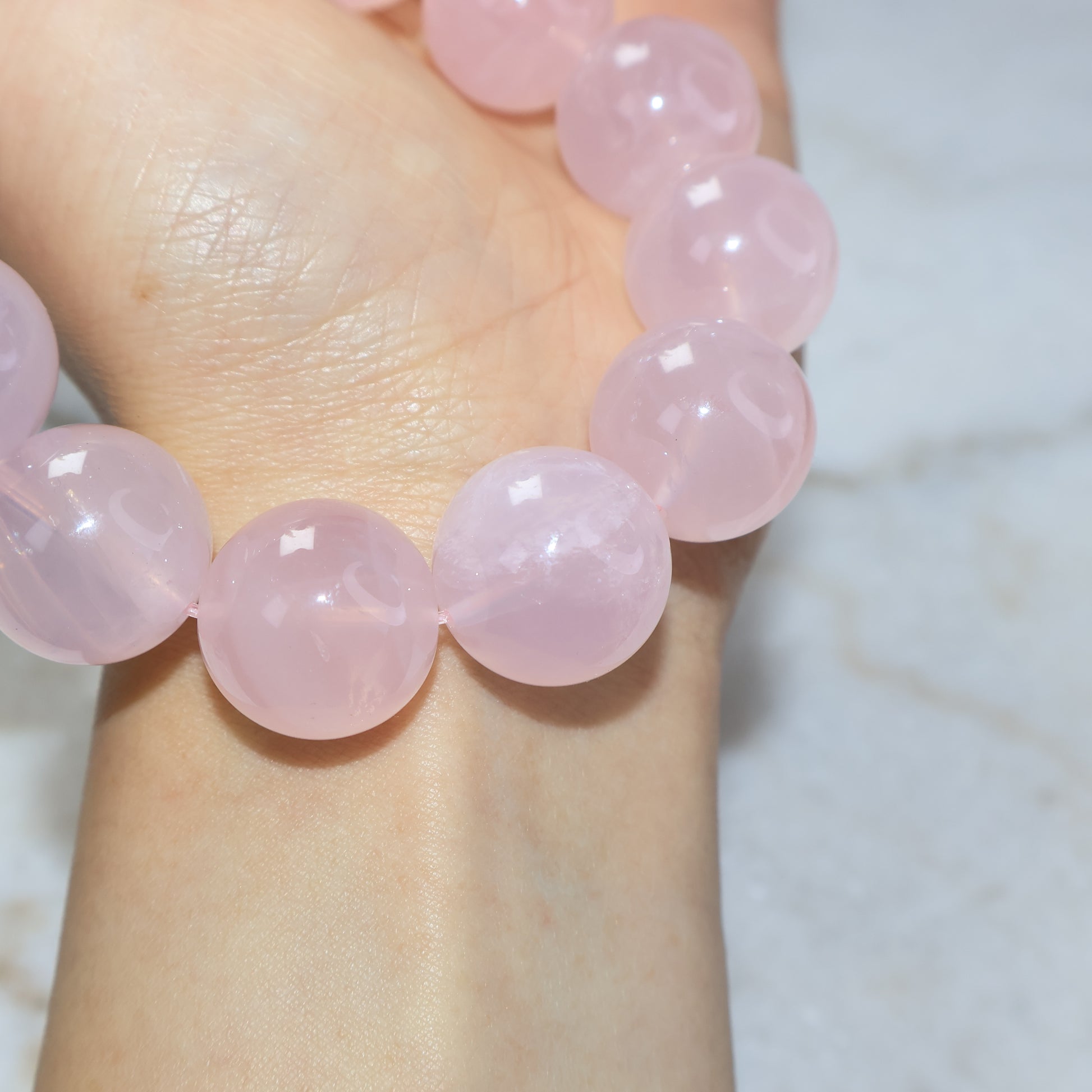 Close-up detail of natural rose quartz beads showing soft pink crystal texture