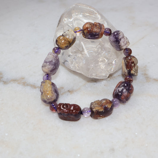 Purple phantom quartz Pixiu bracelet displayed with clear quartz crystal on marble background
