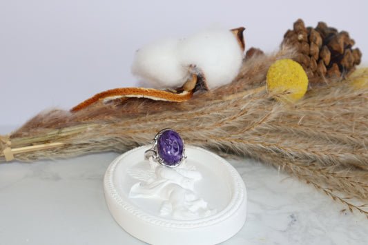Charoite four-prong adjustable silver ring on angel dish with cotton floral background