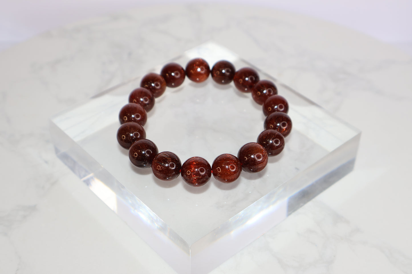 Red Rutilated Quartz bracelet with cat’s eye effect, polished round beads on stretch cord, elegant and radiant gemstone jewelry for energy and vitality.