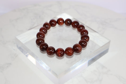 Red Rutilated Quartz bracelet with cat’s eye effect, polished round beads on stretch cord, elegant and radiant gemstone jewelry for energy and vitality.
