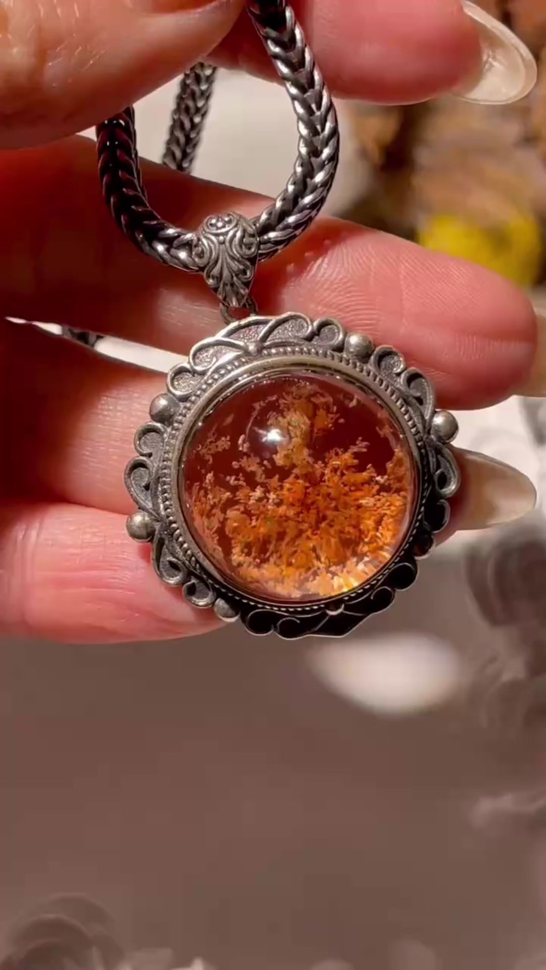 Video showing a 20mm Phantom Quartz pendant with moss-like inclusions, set in an ornate S925 vintage silver frame. The pendant sparkles under light as it moves, highlighting its dreamy internal patterns. Chain not included.